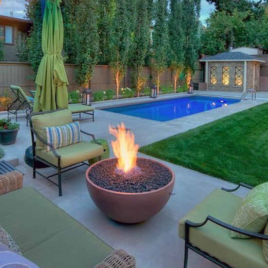 Outdoor Fire Pit next to 3 seats and a swimming pool